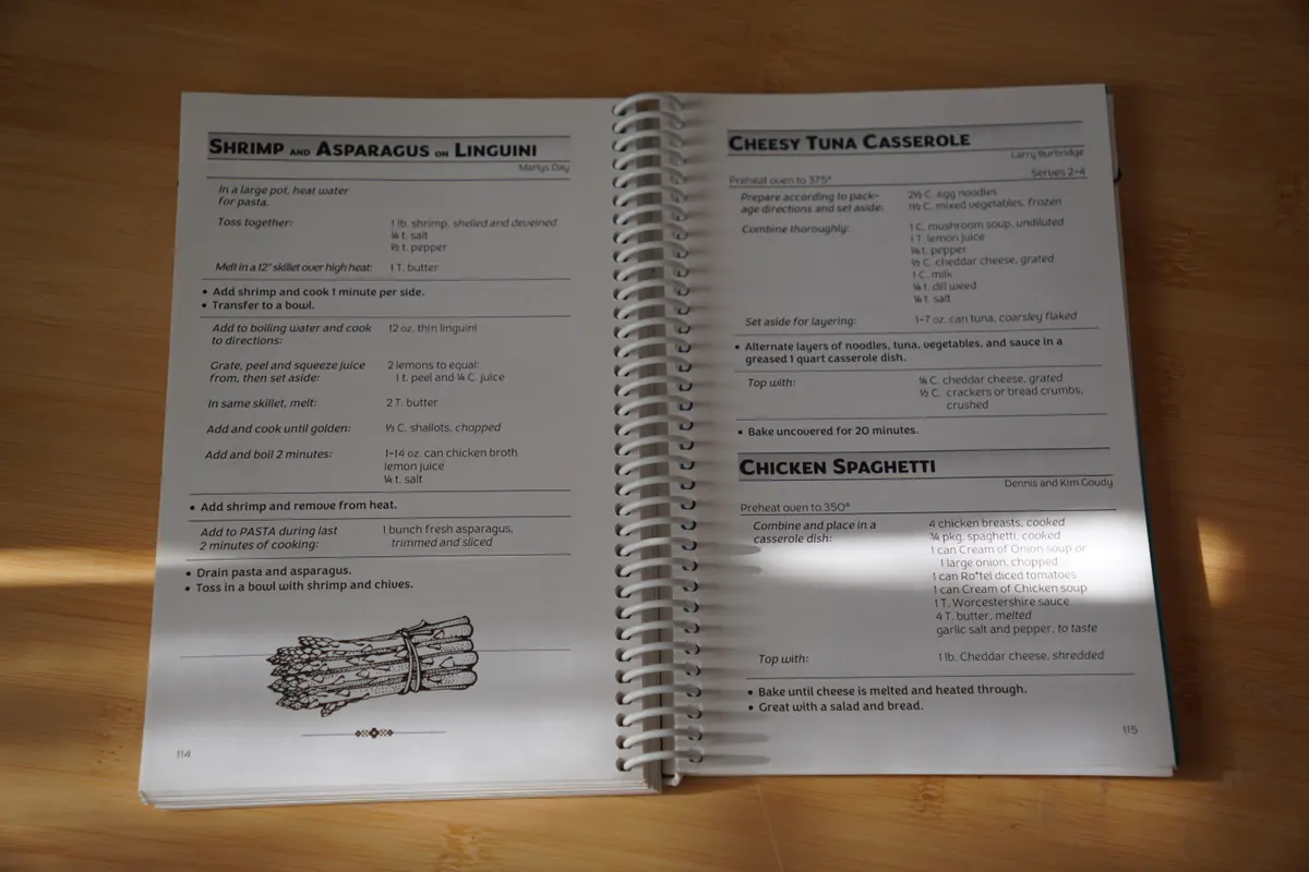 A spiral-bound family recipe book lying open to two recipes